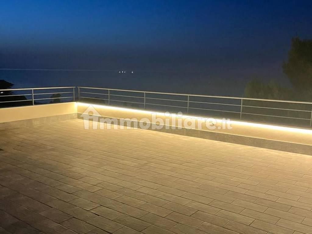 Vista notturna e illuminata di terrazza-solarium