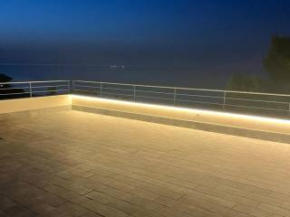 Vista notturna e illuminata di terrazza-solarium