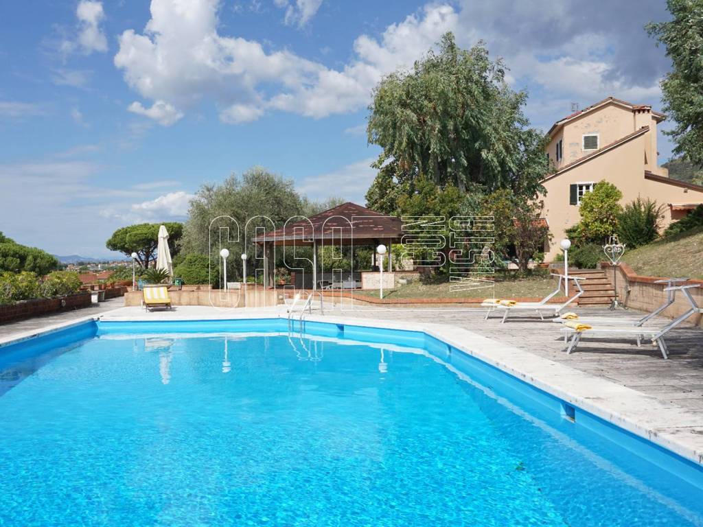 Piscina con solarium e zona pranzo esterna