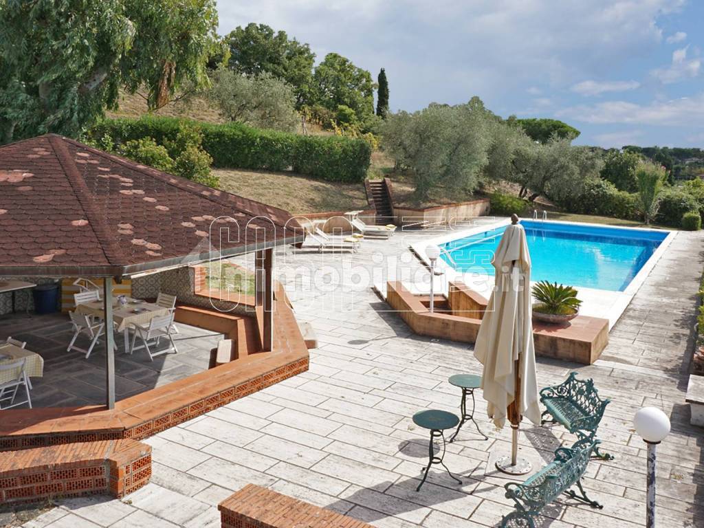 Piscina con solarium e zona pranzo esterna