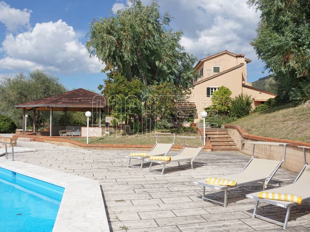 Piscina con solarium e zona pranzo esterna