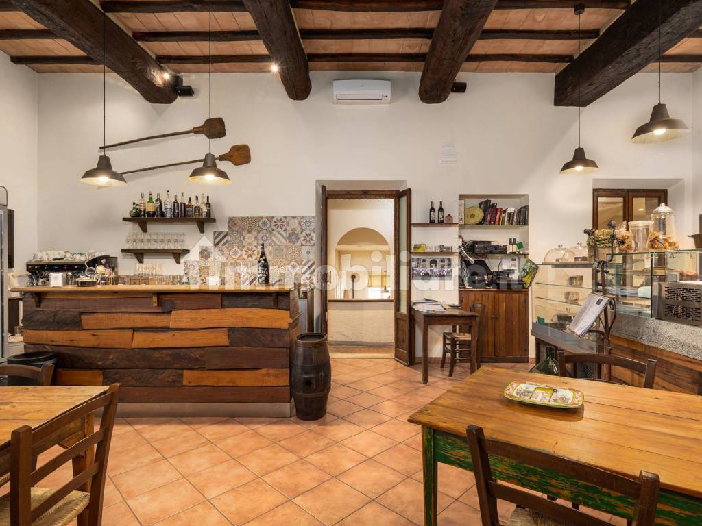 Sala d'ingresso con bar e pizzeria con forno