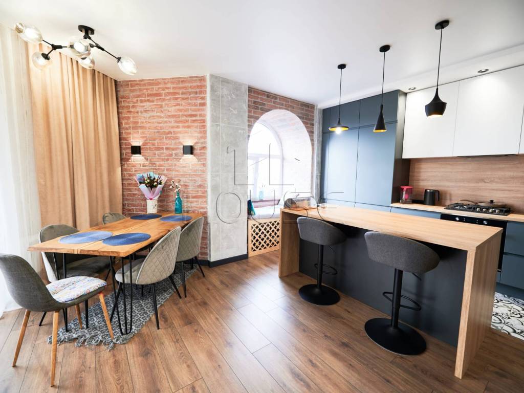 Living room and kitchen studio in dark blue color with modern furniture table, chair and stylish lamps. Concept of stylish modern interior kitchen with bar table.