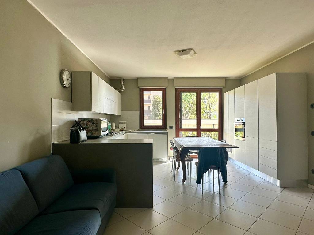 Soggiorno con cucina a vista e accesso al giardino