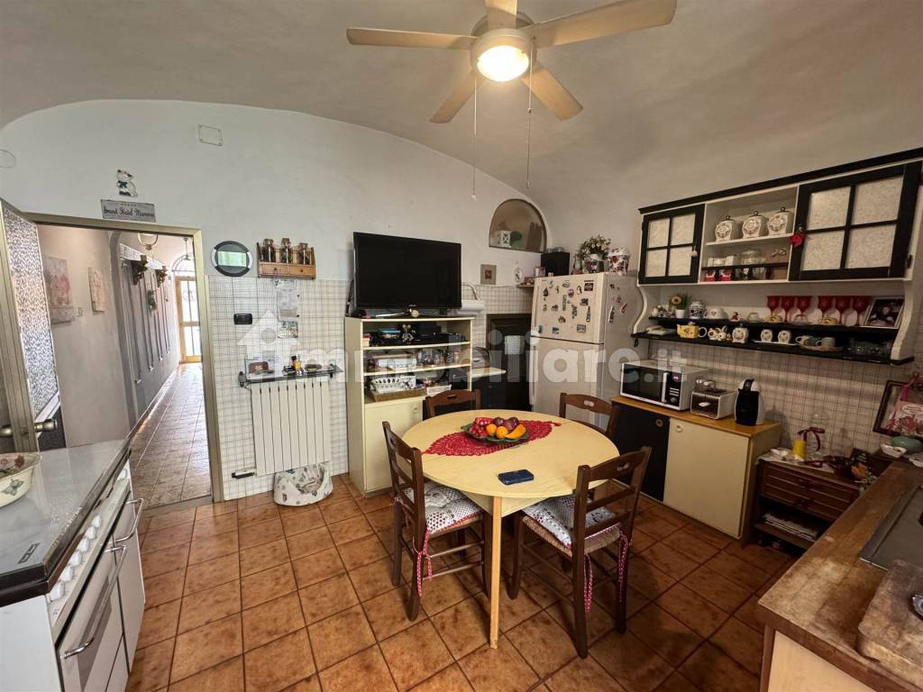 Cucina con sottoscala e ingresso alla veranda