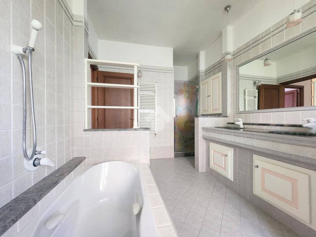 sala da bagno con vasca incassata e box doccia in cristallo
