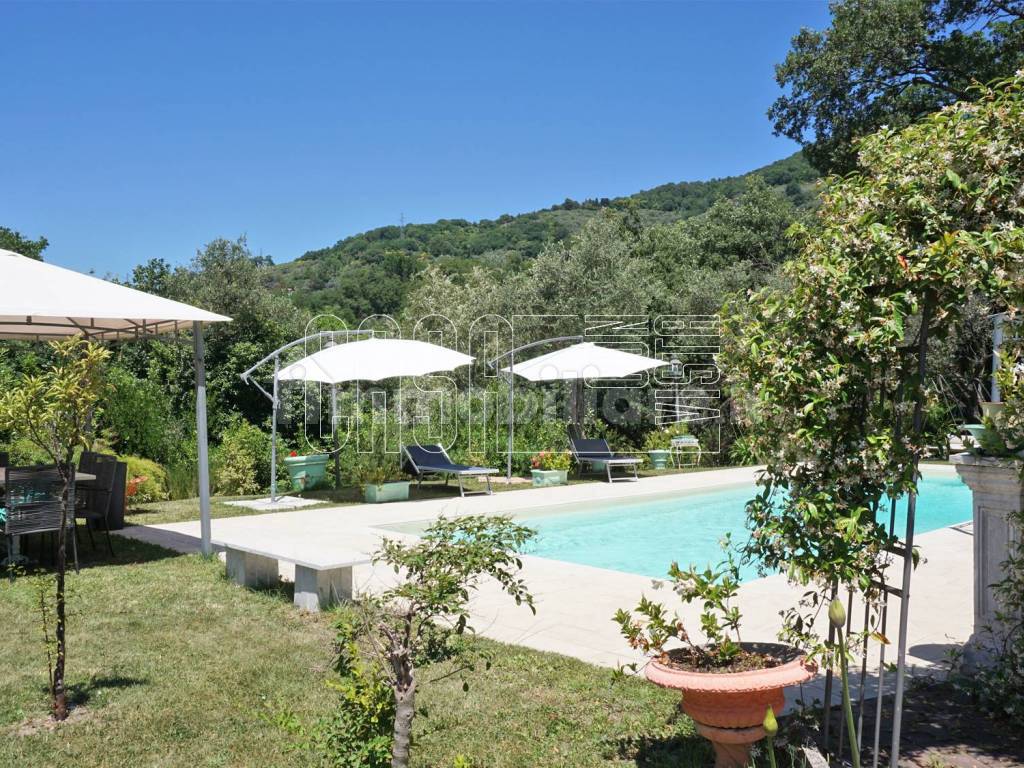 Piscina con solarium e zona pranzo